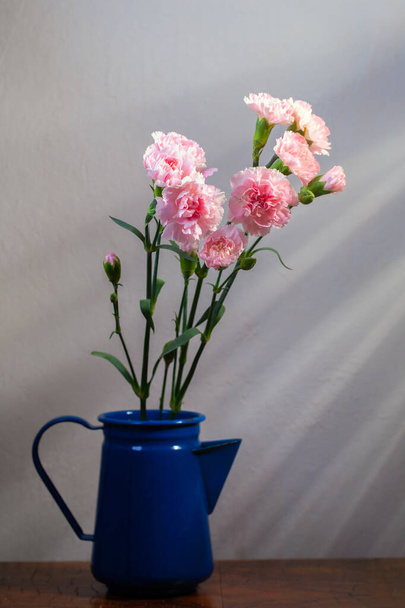 still-life. a bouquet of pink carnations against a white wall in the morning sun - Foto, Imagem