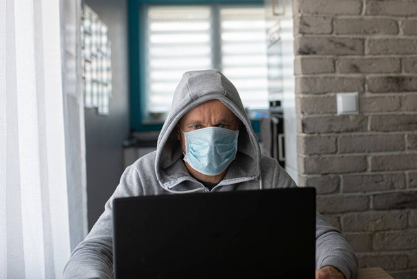 Man working at home in medical mask. Home office - Foto, afbeelding