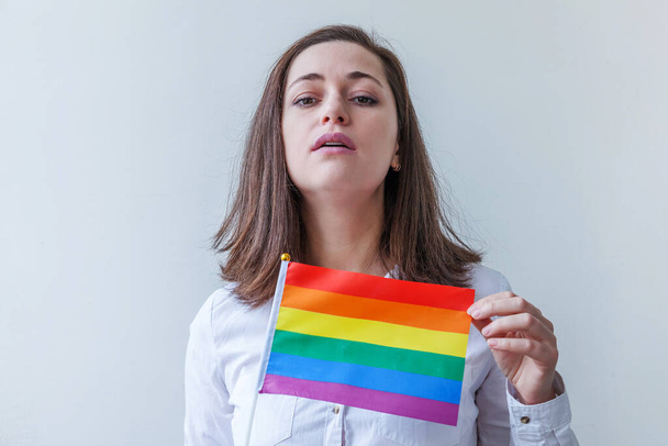Beautiful caucasian lesbian girl with LGBT rainbow flag isolated on white background looking happy and excited. Young woman Gay Pride portrait. Equal rights for lgbtq community concept - Foto, imagen