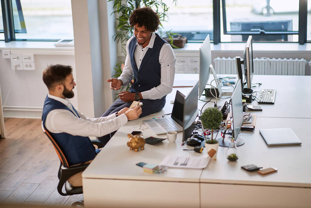 Smiling businessmen talking at work in modern office.Businessman with money in hand, investment, success and profitable business concepts. - Foto, Bild