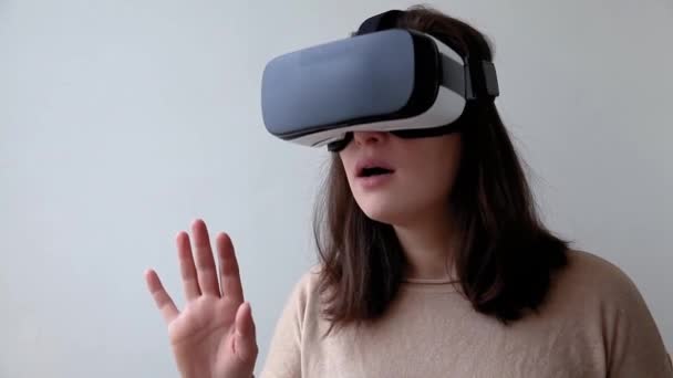 Улыбнитесь молодой женщине в шлеме виртуальной реальности VR очки на белом фоне. Смартфон с очками виртуальной реальности. Технологии, технологии, хай-тек, концепция видеоигр - Кадры, видео