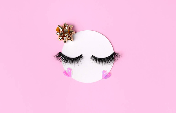 Creative layout with eyelashes. Closed eyes on pastel pink background. Minimal template postcard good morning concept. - Photo, Image