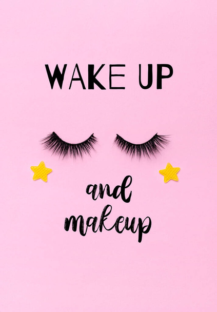 Greeting card with eyelashes and text: wake up and makeup. Closed eyes with stars on pink background. - Foto, Imagen