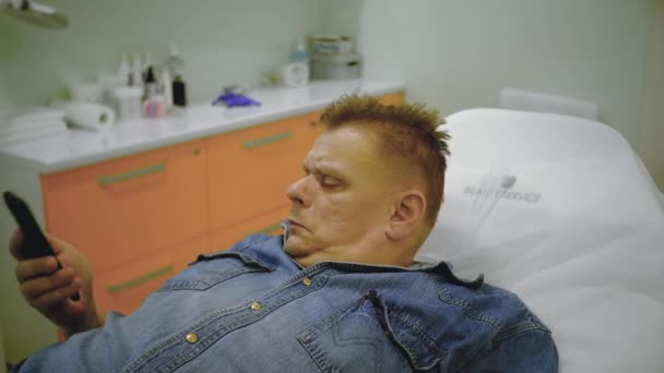 homme allongé sur un lit médical et parlant sur un téléphone portable
 - Séquence, vidéo