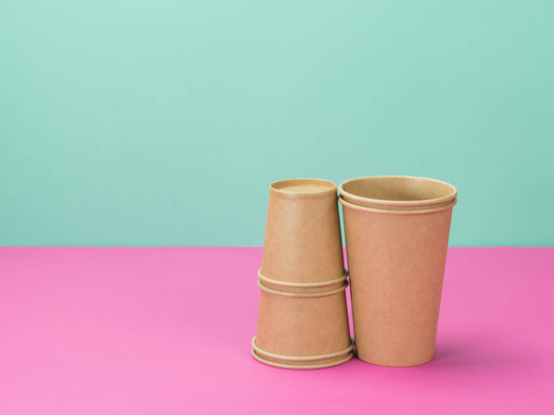 Tasses en papier jetables sur fond rose et turquoise. Eco tasses
. - Photo, image