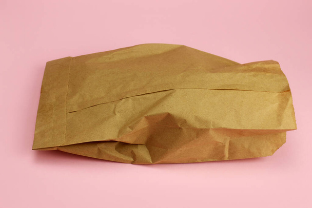 Kraft χάρτινη τσάντα με φαγητό σε ροζ φόντο - Φωτογραφία, εικόνα