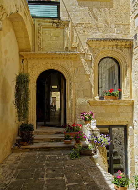 Preciosos patios italianos con portales tallados, flores y pintorescas paredes de piedra
. - Foto, Imagen