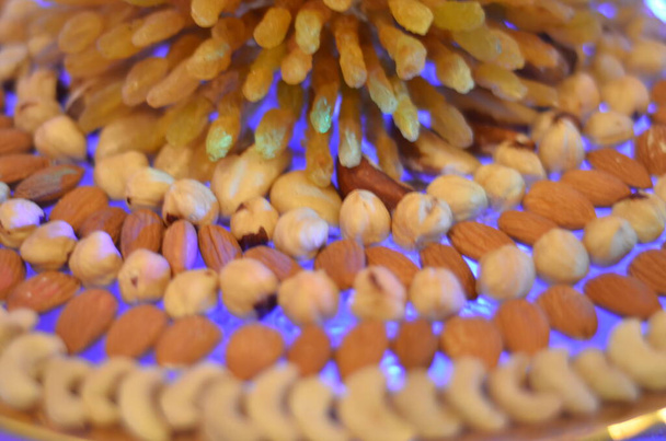 Nüsse und Rosinen auf Teller mit weichem Fokus angeordnet - Foto, Bild