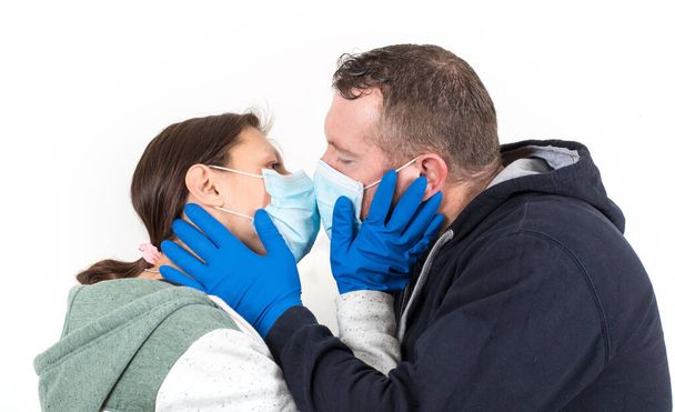 Couple wearing a virus face mask kissing concept for corona virus  - Fotó, kép