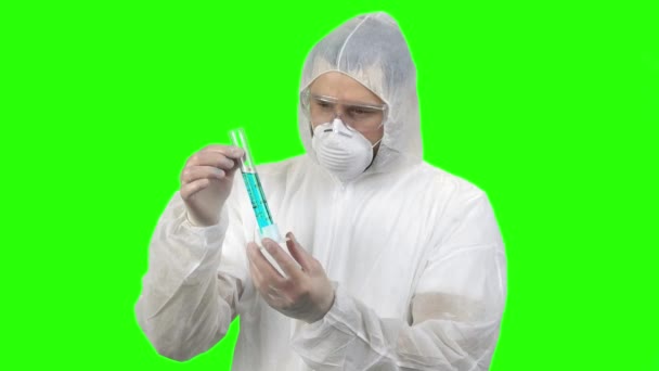 Man in respiratory and protective clothing holding test tube with blue liquid. - Záběry, video
