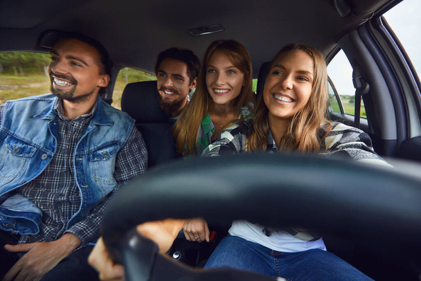 A group of happy friends are driving in a car. - Photo, image