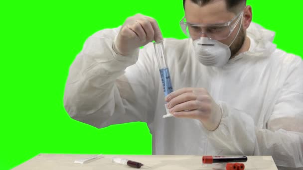 Joven científico revolviendo líquido azul en un tubo de ensayo
. - Imágenes, Vídeo