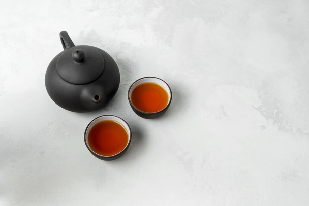 Fundo de comida asiática com um conjunto de chá, copos e bule de chá com espaço livre para texto sobre fundo de pedra branca
. - Foto, Imagem