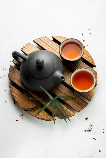 Asian food background with a tea set, cups, and teapot with free space for text on white stone background. Flat lay asian tea background. - Φωτογραφία, εικόνα