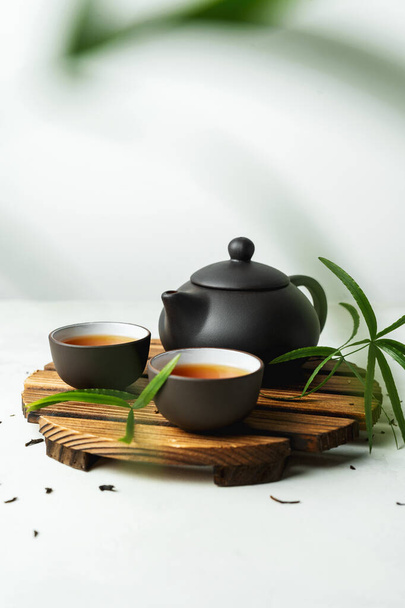 Asian food background with a tea set, cups, and teapot with free space for text on white stone background. - Photo, image