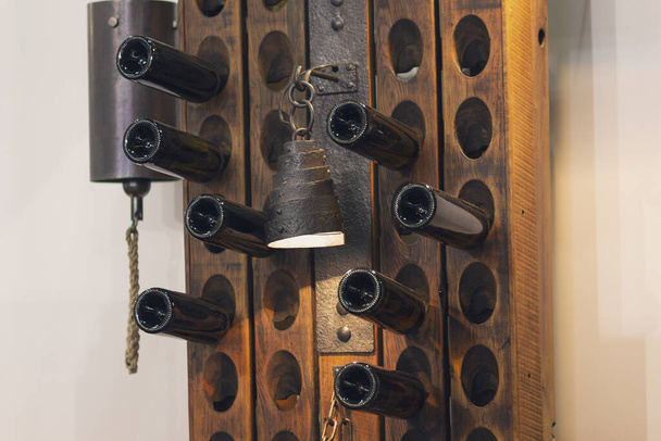 Boden einer Flasche Wein im Regal und eine Lampe im Retro-Stil. Innenraum - Foto, Bild