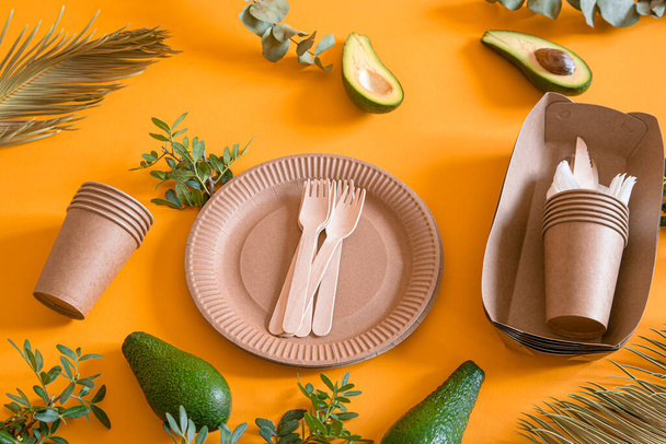 Eco-friendly, stylish recyclable paper tableware. Paper food boxes, plates, and cornstarch Cutlery on a trending orange background. - Photo, Image