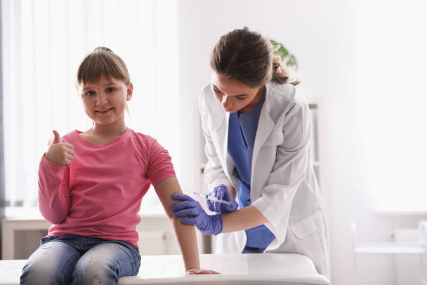 Pikkutyttö saa vesirokkorokotuksen klinikalla. vesirokkoviruksen ehkäisy
 - Valokuva, kuva