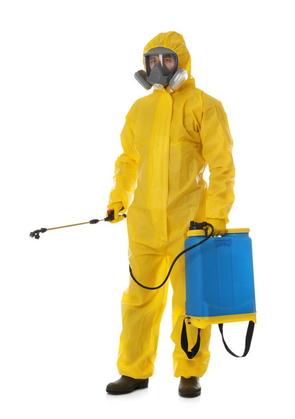 Man wearing protective suit with insecticide sprayer on white background. Pest control - Фото, изображение
