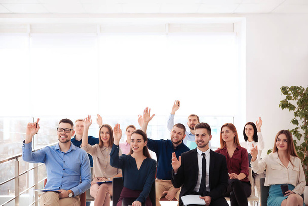 Люди поднимают руки, чтобы задать вопросы на бизнес-тренинге в помещении
 - Фото, изображение