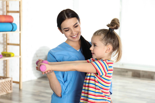 Orthopedist working with little girl in hospital gym - Fotó, kép