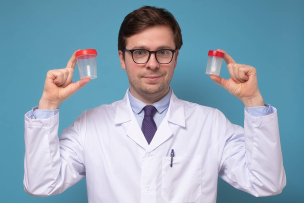 尿サンプルカップを保持している成熟したcaucaisai医師または研究室の科学者. - 写真・画像