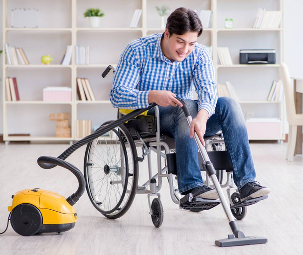 Hombre discapacitado limpiando casa con aspiradora - Foto, Imagen