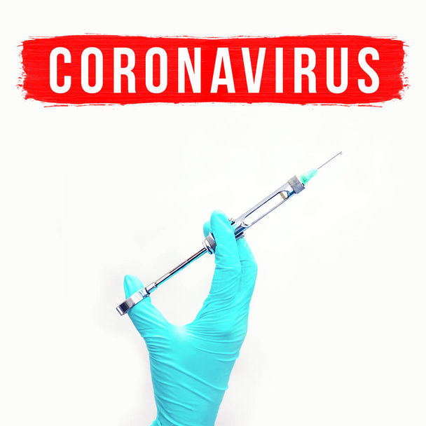 Hand in glove with medical syringe. A concept on the theme of coronavirus. On the light background - Zdjęcie, obraz