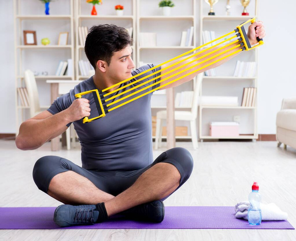 Young man exercising at home in sports and healthy lifestyle con - Photo, Image