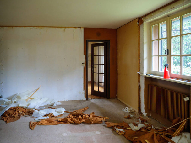 Vista interna della stanza della casa durante i lavori di ricostruzione con arazzo tessile abbattuto dalle pareti
 - Foto, immagini