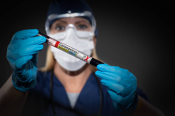 Γυναίκα Lab εργαζόμενος κατέχει σωλήνα δοκιμής του αίματος Labeled Coronavirus COVID-19 ασθένεια. - Φωτογραφία, εικόνα
