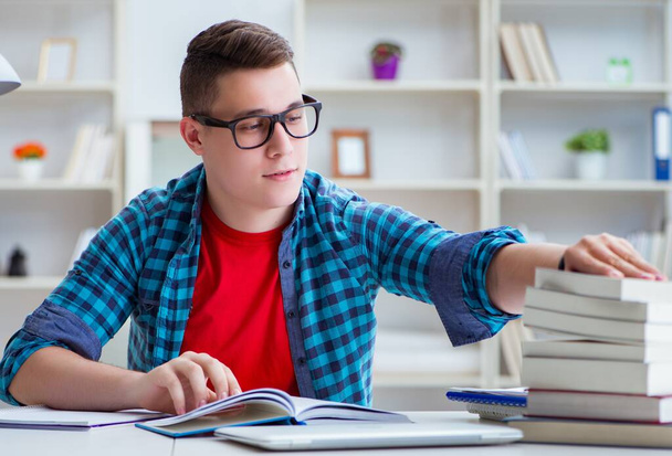 Adolescente joven preparándose para los exámenes que estudian en un escritorio en el interior - Foto, imagen