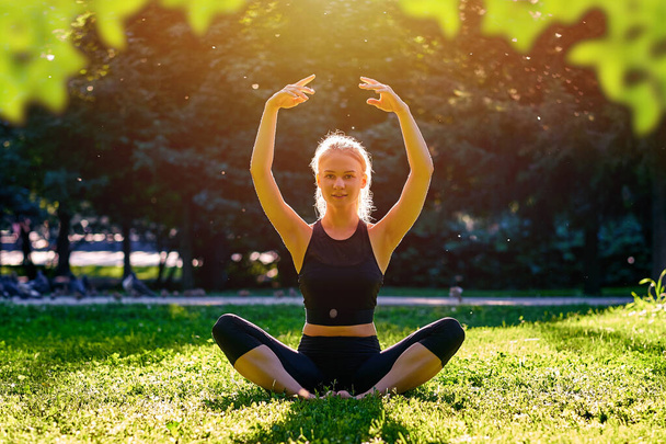 Jóga. Mladá žena cvičí jógu, tancuje nebo se protahuje v přírodě v parku. Zdravotní životní styl koncept. - Fotografie, Obrázek