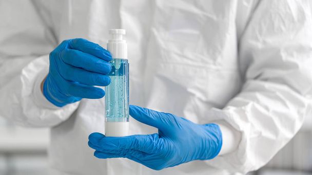Gel de lavage des mains Hygiène est emballé dans des bouteilles en verre par des experts chimiques
. - Photo, image