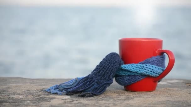 Красная чашка с горячим кофе и парным чаем, повязанная синим вязаным шарфом
 - Кадры, видео