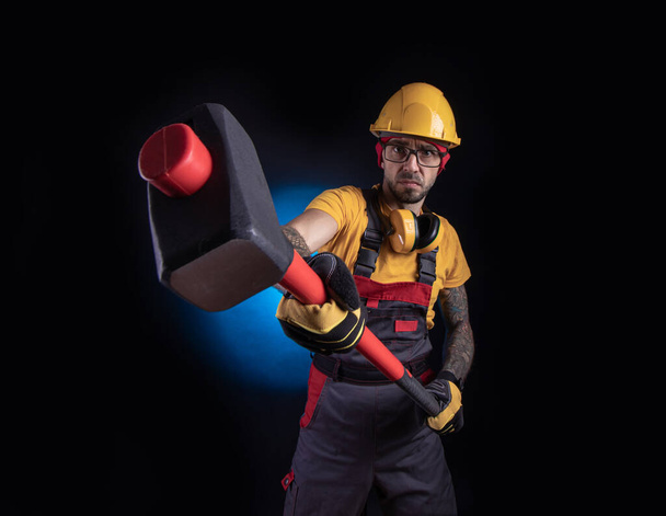 el trabajador de la construcción con un martillo de trineo
 - Foto, imagen
