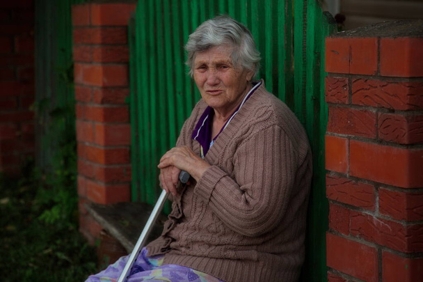 Retrato de un pensionista ruso descansando en un banco cerca de la casa
. - Foto, Imagen