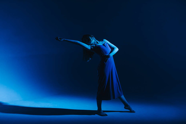 Jong stijlvol meisje dansend in de Studio op een gekleurde neon achtergrond. Klassieke danser. - Foto, afbeelding