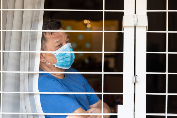 Розлючений китаєць з маскою обличчя самоізолюється вдома протягом 14 днів, побоюючись контакту з вірусом covid-19. - Фото, зображення