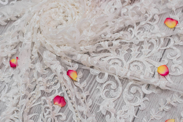 Witte houten achtergrond met witte lentebloemen rozen en kanten lint. Gelukkige vrouwendag. De textuur van kant op houten ondergrond. - Foto, afbeelding