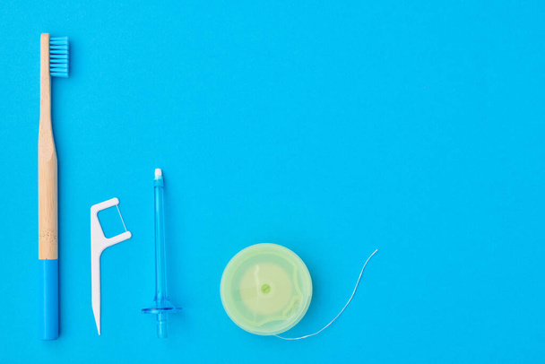 Οδοντόβουρτσες και εργαλεία στοματικής φροντίδας σε μπλε φόντο. Οδοντιατρική περίθαλψη, οδοντιατρική υγιεινή και υγεία.  - Φωτογραφία, εικόνα