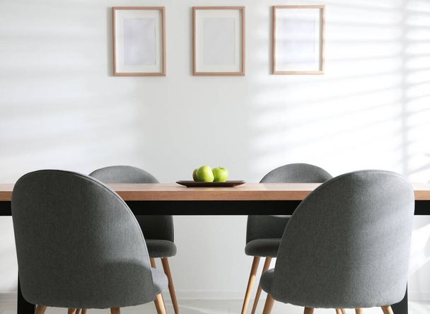 Plate with apples on wooden table indoors. Stylish interior design - Foto, afbeelding