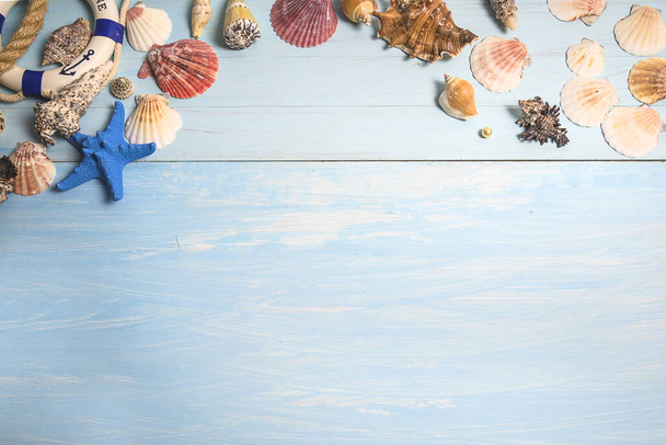 Strandurlaub im Hintergrund. Rahmen verschiedener Muscheln und Seesterne auf blauem Farbholzhintergrund. Platz für Text, Draufsicht - Foto, Bild
