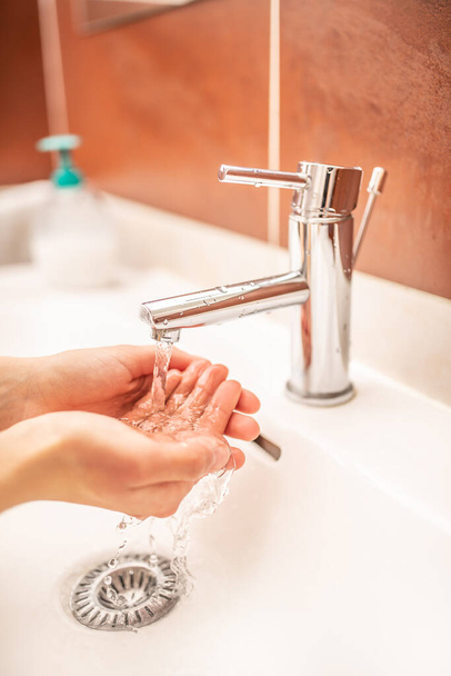 Washing hands with water and liquid soap in the bathroom - Фото, зображення