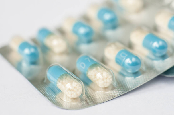 Zbliżenie niebiesko-białe tabletki antybiotykowe w blistrze. Przeszłość apteki. Przeciwbakteryjna oporność na leki. Przemysł farmaceutyczny. Globalna opieka zdrowotna. - Zdjęcie, obraz