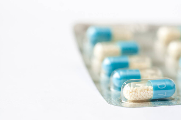Lähikuva sinivalkoisia antibiootteja kapseli pillereitä läpipainopakkauksessa. Apteekkitausta. Mikrobilääkeresistenssi. Lääketeollisuus. Globaali terveydenhuolto
. - Valokuva, kuva