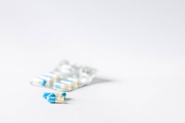 Szekrény kék-fehér antibiotikumok kapszula tabletták buborékcsomagolásban. Gyógyszerészeti háttér. Antimikrobiális gyógyszerrezisztencia. Gyógyszeripar. Globális egészségügy. - Fotó, kép