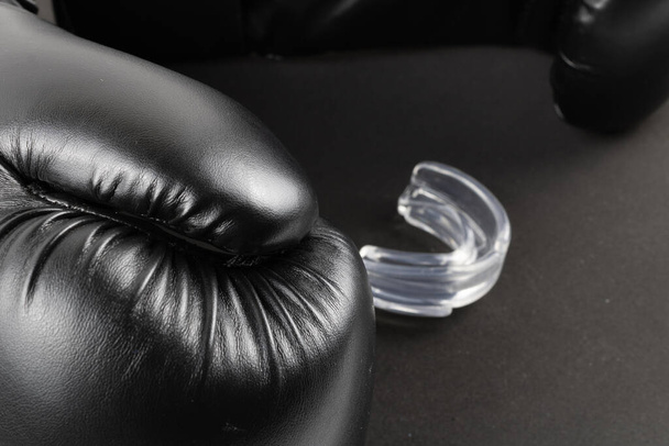 Boxing gloves and a mouth guard on a black background. product image - Photo, Image