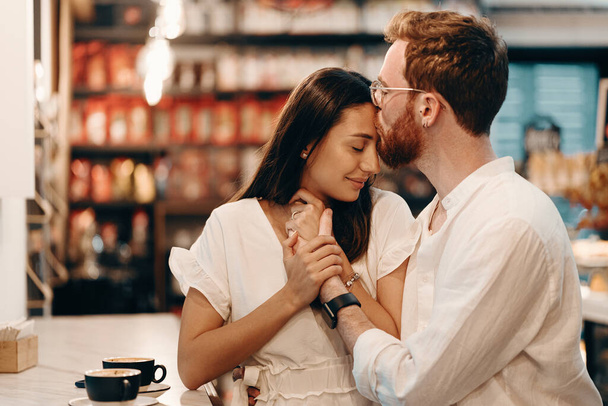 Liebespaar in einem Café. glückliches junges Paar trinkt Kaffee und lächelt, während es in einem Café sitzt - Foto, Bild