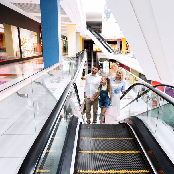Familia en compras Subiendo escaleras mecánicas en hipermercado
 - Foto, imagen